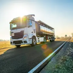 Ciężarówka cysterna na drodze o wschodzie słońca. Bezpieczny transport to podstawa, dlatego warto pamiętać o darmowe testy adr.