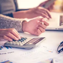 Ręce liczą na kalkulatorze i piszą na laptopie, analizując raporty. Jak liczyć dieta zagraniczna?