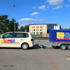 Samochód nauki jazdy z przyczepą. Na przyczepie informacja o kategoriach prawa jazdy, w tym B+E ile ton.