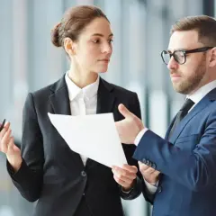 Biznesmeni omawiają dokumenty. Długie godziny pracy, jak dieta powyżej 8 godzin, wymagają skupienia i współpracy.