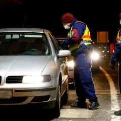 Policjanci w kamizelkach odblaskowych kontrolują samochód. To część działań związanych z imi delegowanie kierowców.