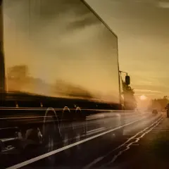 Ciężarówka ADR pędzi autostradą o zachodzie słońca. Kierowca ADR wiezie ważny ładunek.