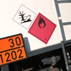Pomarańczowa tablica z numerem 30 i 1202, obok niej symbol płomienia i symbol z rybą. To numer ONZ.