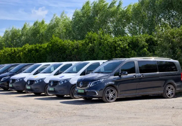 Rząd ciemnych i białych busów gotowych do przewozów busem po Polsce.