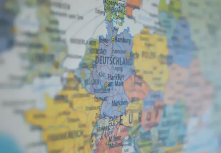 Mapa Europy z zaznaczoną DEUTSCHLAND. Widać miasta takie jak Hamburg, Frankfurt, Monachium. W tle widoczne są landy niemieckie, zakazy podróżowania w Europie.