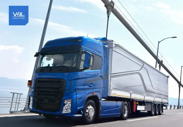 Niebieska ciężarówka z naczepą na moście, symbolizująca sprawną spedycję transport krajowy.