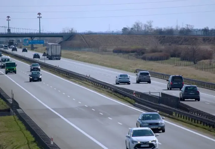 Ruch na autostradzie, gdzie kierowcy zastanawiają się, jaki mandat za jazdę ciężarówka w zakazie.