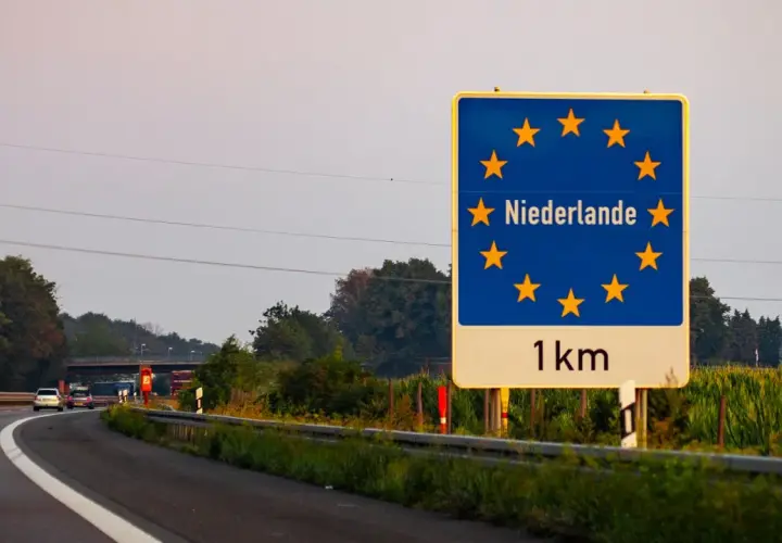 Granica z Holandią, winieta nl. Znak informuje o zbliżaniu się do Holandii, 1 km.