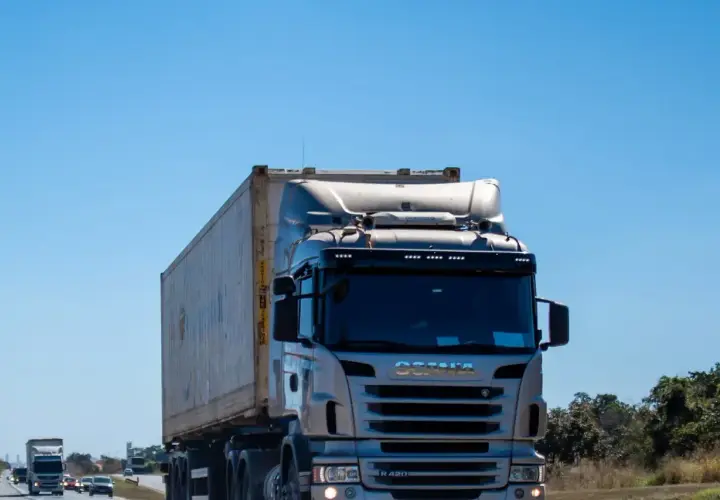 Ciężarówka Scania przewozi kontener. Zastanawiasz się, ile za kilometr busem po Polsce?