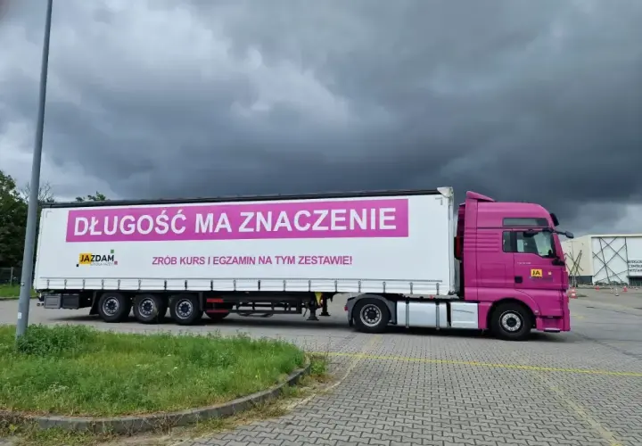Różowa ciężarówka z napisem "Długość ma znaczenie. Zrób kurs i egzamin na tym zestawie!" zachęca do **testów na przewóz rzeczy**.