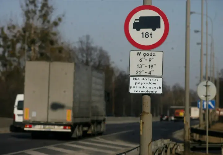 Znak zakazu ruchu dla pojazdów powyżej 18 ton w określonych godzinach.