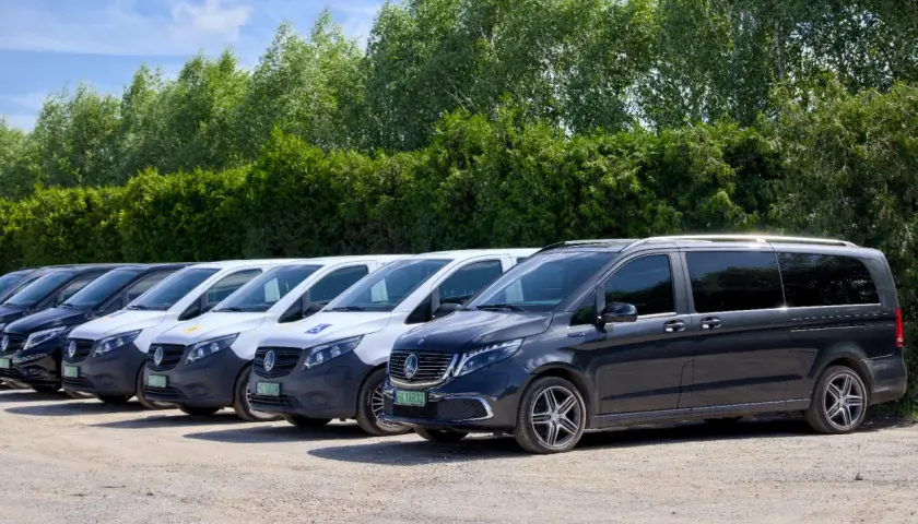 Rząd ciemnych i białych busów gotowych do przewozów busem po Polsce.