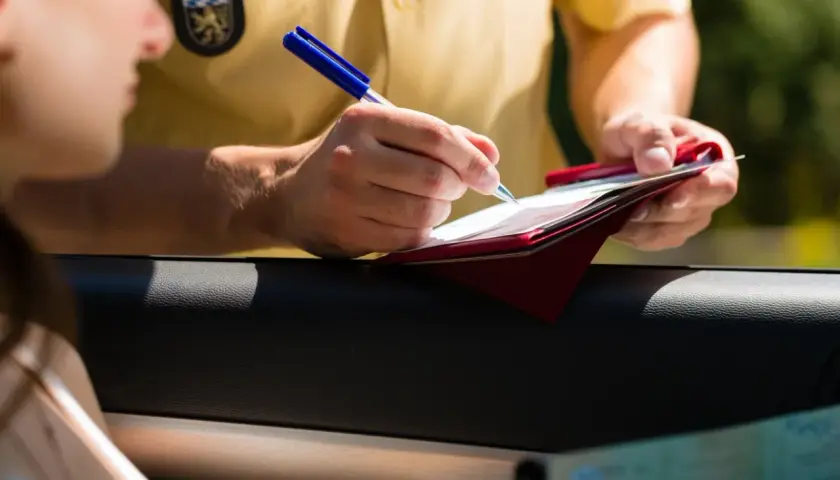 Policjant spisuje mandaty w Niemczech. Kierowca pokazuje dokumenty.
