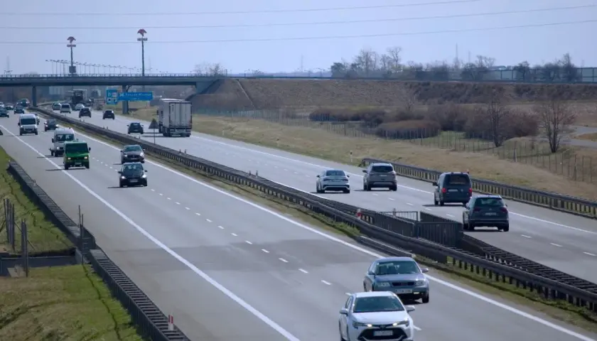 Ruch na autostradzie, gdzie kierowcy zastanawiają się, jaki mandat za jazdę ciężarówka w zakazie.