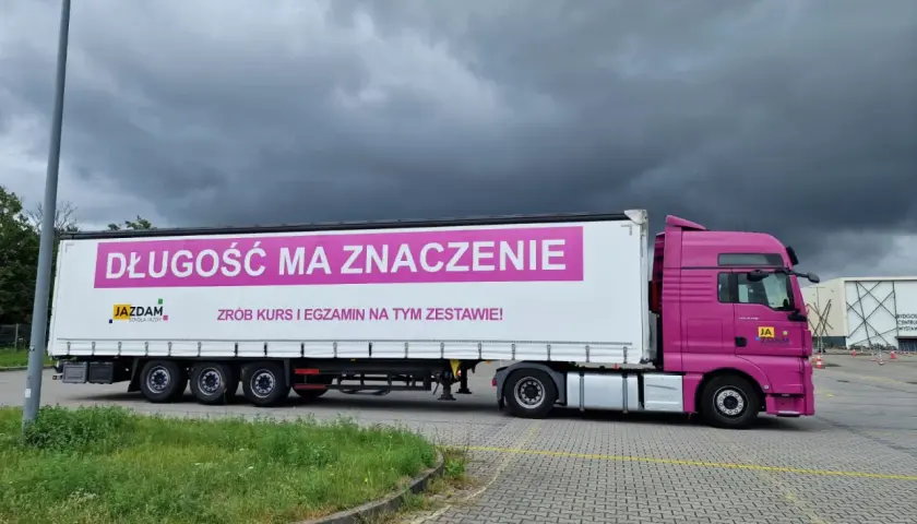 Różowa ciężarówka z napisem "Długość ma znaczenie. Zrób kurs i egzamin na tym zestawie!" zachęca do kwalifikacji wstępnej uzupełniającej.