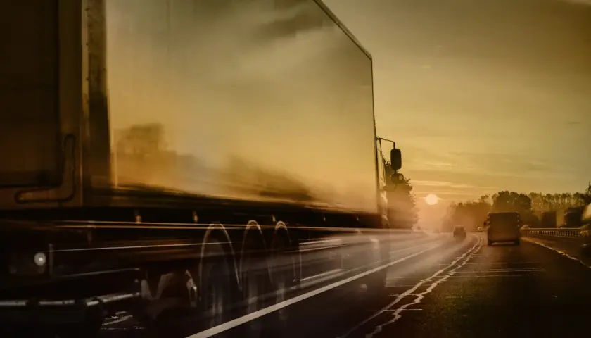 Ciężarówka ADR pędzi autostradą o zachodzie słońca. Kierowca ADR wiezie ważny ładunek.