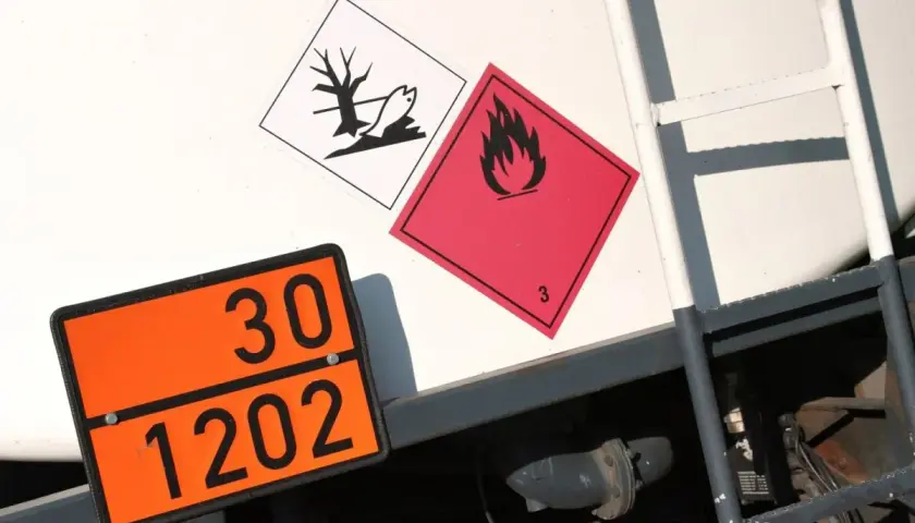 Pomarańczowa tablica z numerem 30 i 1202, obok niej symbol płomienia i symbol z rybą. To numer ONZ.