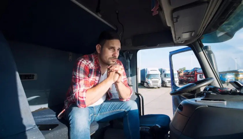 Kierowca w kabinie ciężarówki zamyślony, zastanawia się, jak rozliczać delegacje.