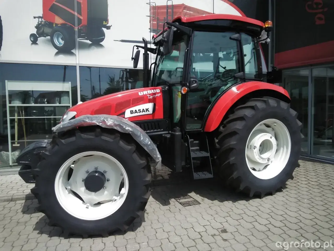 Czerwony traktor Ursus Basak, idealny do pracy w polu. Posiadając prawo jazdy kat B+T uprawnienia, możesz nim legalnie jeździć.