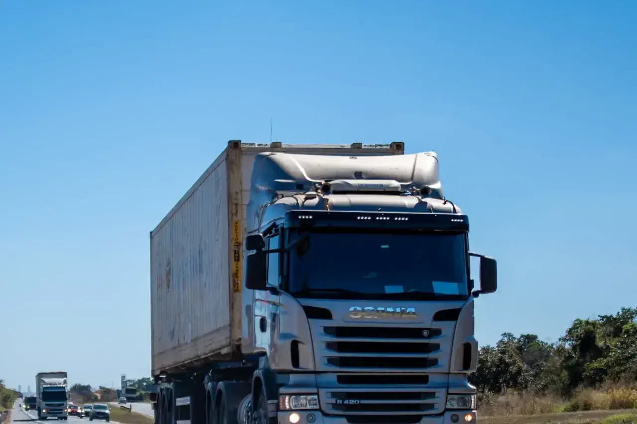 Ciężarówka Scania przewozi kontener. Zastanawiasz się, ile za kilometr busem po Polsce?