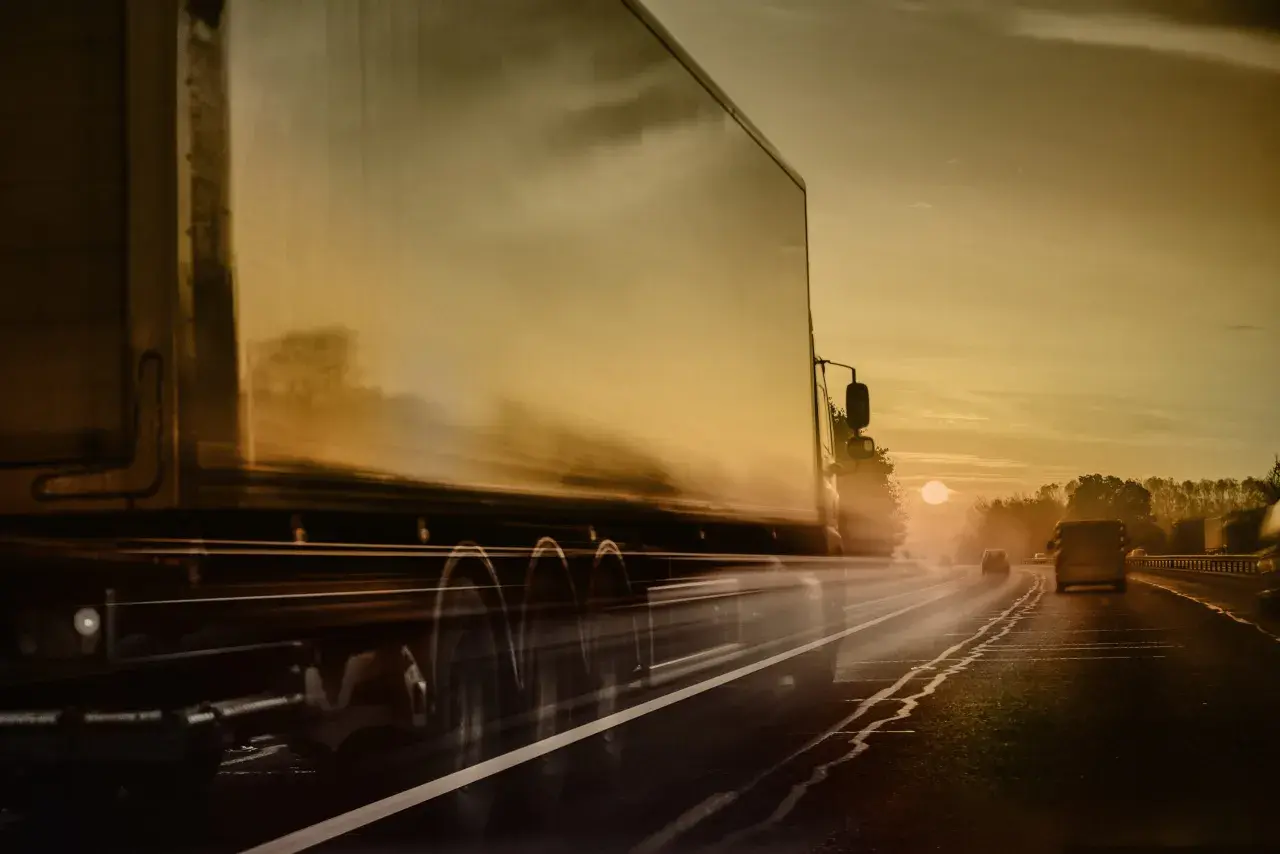 Ciężarówka ADR pędzi autostradą o zachodzie słońca. Kierowca ADR wiezie ważny ładunek.